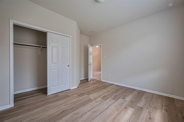 3934 Medici Ct, Missouri City, TX 77459 - unfurnished bedroom with light wood finished floors, a closet, and baseboards