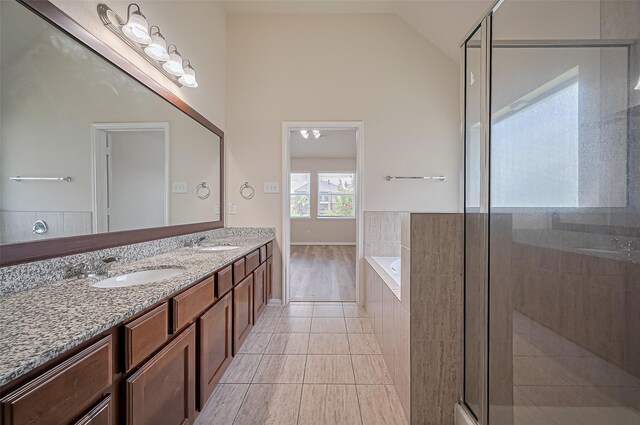 3934 Medici Ct, Missouri City, TX 77459 - bathroom featuring a bath, double vanity, a stall shower, vaulted ceiling, and tile patterned floors