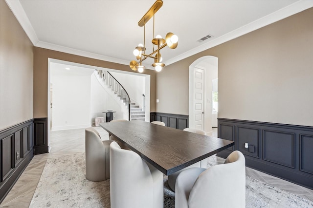 11207 Cosmopolitan Dr, Cypress, TX 77433 - dining room featuring crown molding, a wainscoted wall, arched walkways, stairway, and a chandelier
