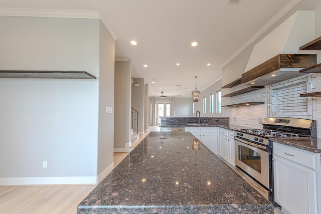 1205 Sampson St, Houston, TX 77003 - kitchen with gas stove, open shelves, tasteful backsplash, crown molding, and a center island