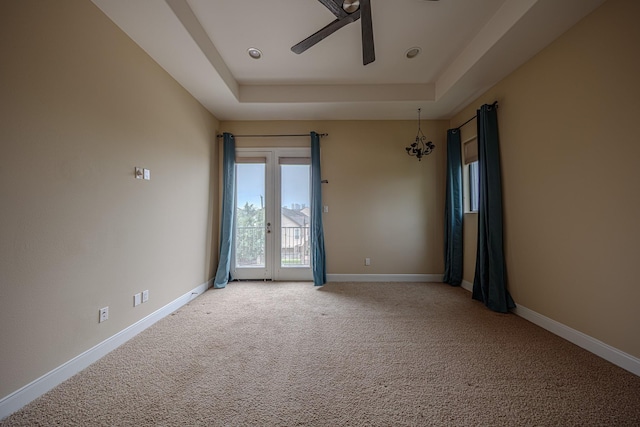 1205 Sampson St, Houston, TX 77003 - spare room with ceiling fan, a tray ceiling, light colored carpet, and a chandelier