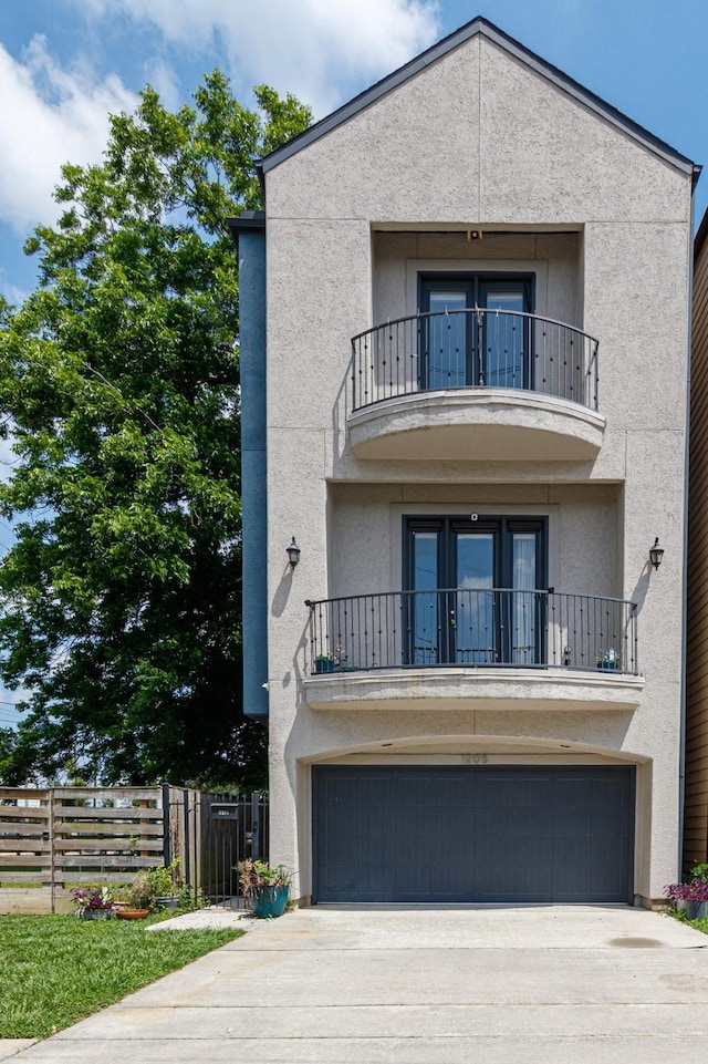 1205 Sampson St, Houston, TX 77003 - view of front of home with a balcony, a garage, french doors, concrete driveway, and stucco siding