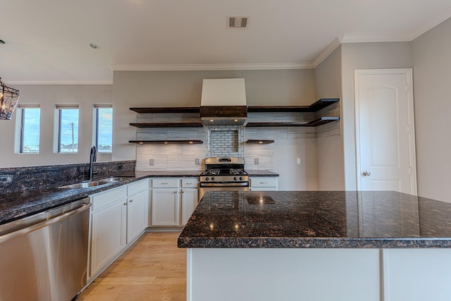 1205 Sampson St, Houston, TX 77003 - kitchen with appliances with stainless steel finishes, open shelves, light wood-style flooring, dark stone counters, and ornamental molding