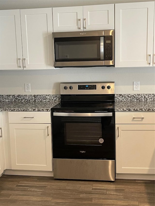 15508 Taylorcrest Dr, Conroe, TX 77306 - kitchen featuring appliances with stainless steel finishes, white cabinets, dark stone counters, and dark wood-type flooring