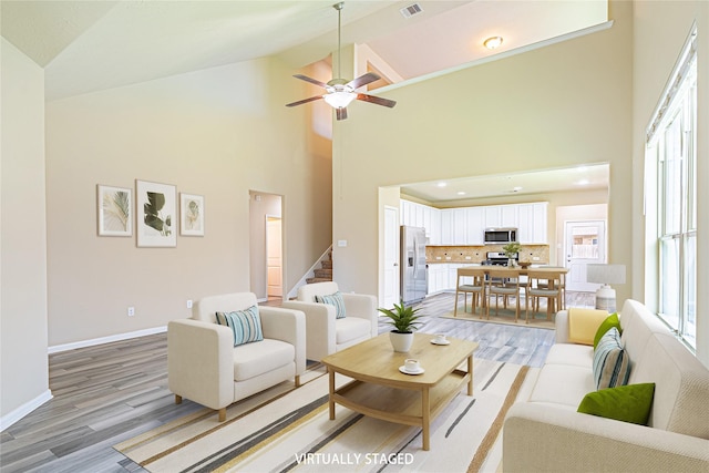 8138 Heartbrook Field Ln, Cypress, TX 77433 - living area featuring high vaulted ceiling, stairs, light wood-style flooring, and a ceiling fan