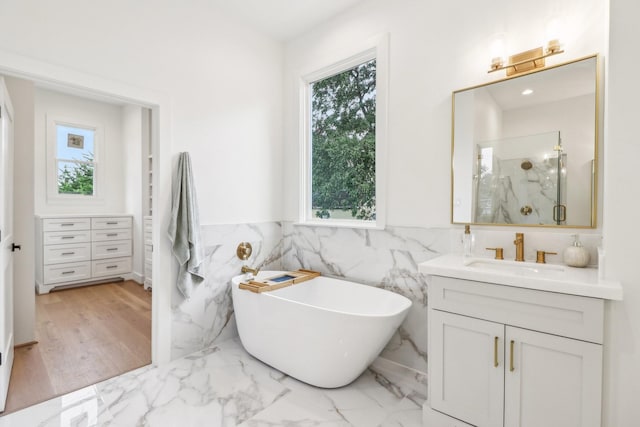 412 Hawthorne St, Houston, TX 77006 - full bath featuring vanity, a marble finish shower, tile walls, a soaking tub, and wainscoting