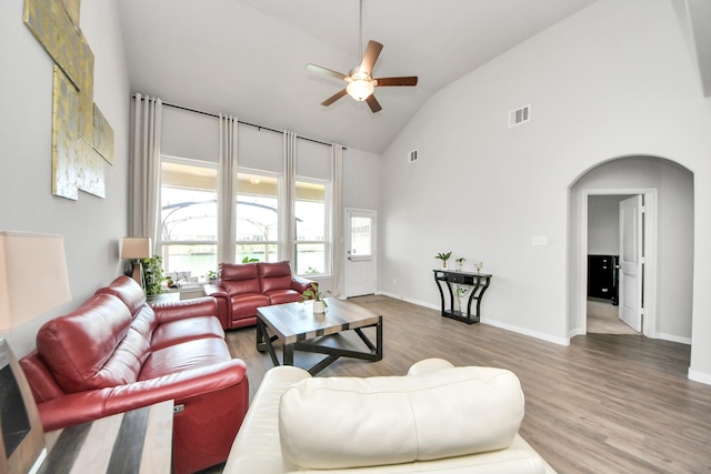 24810 Puccini Pl, Katy, TX 77493 - living room featuring high vaulted ceiling, ceiling fan, wood finished floors, arched walkways, and baseboards