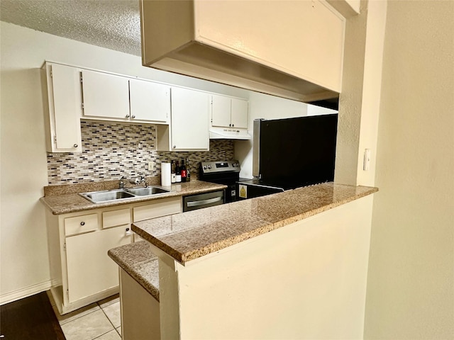 2750 Holly Hall St Unit 1215, Houston, TX 77054 - kitchen featuring under cabinet range hood, stainless steel appliances, decorative backsplash, a peninsula, and white cabinetry