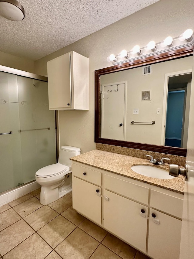 2750 Holly Hall St Unit 1215, Houston, TX 77054 - bathroom with a textured ceiling, vanity, tile patterned floors, a shower stall, and toilet