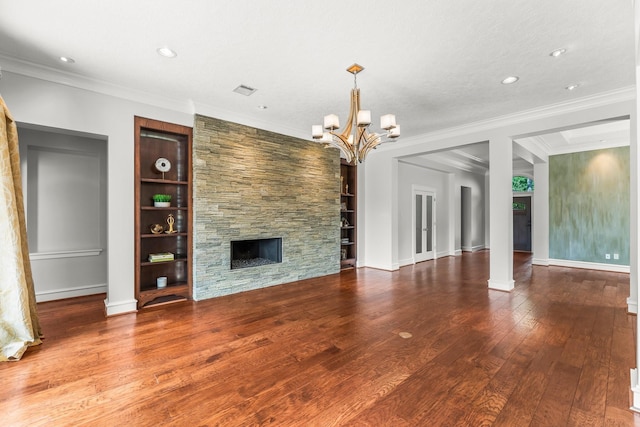 44 Vinebrook Rd, The Woodlands, TX 77380 - unfurnished living room with hardwood / wood-style flooring, built in shelves, a chandelier, a fireplace, and ornamental molding
