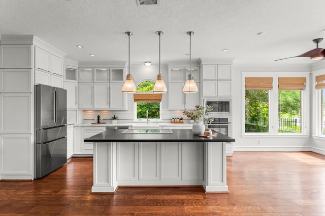 44 Vinebrook Rd, The Woodlands, TX 77380 - kitchen featuring stainless steel appliances, a center island, dark wood finished floors, hanging light fixtures, and a sink