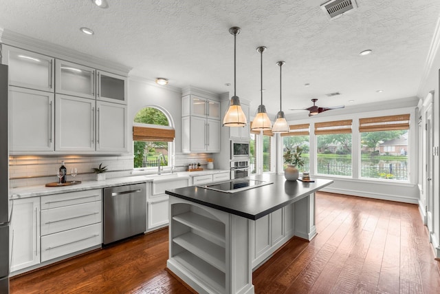 44 Vinebrook Rd, The Woodlands, TX 77380 - kitchen featuring appliances with stainless steel finishes, open shelves, decorative backsplash, dark wood-style flooring, and a textured ceiling
