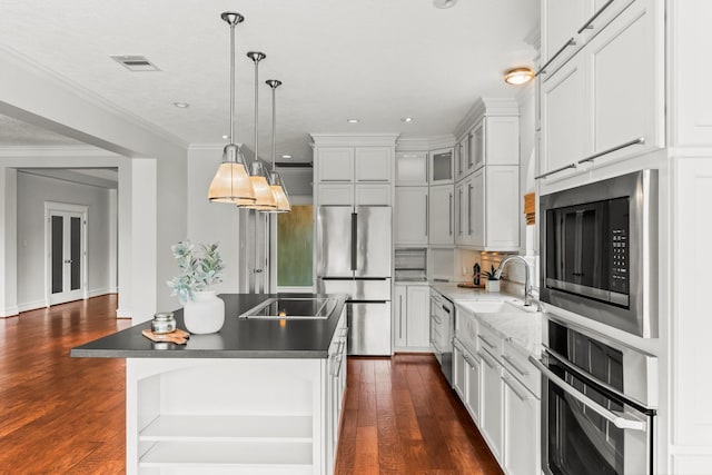 44 Vinebrook Rd, The Woodlands, TX 77380 - kitchen featuring appliances with stainless steel finishes, dark wood-style floors, recessed lighting, dark countertops, and decorative light fixtures