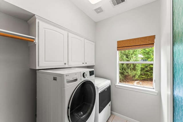 44 Vinebrook Rd, The Woodlands, TX 77380 - laundry room featuring cabinet space, washing machine and clothes dryer, light tile patterned floors, and baseboards