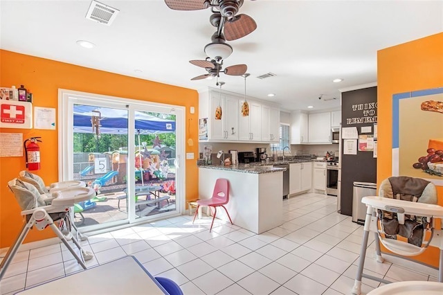 5302 Treaschwig Rd, Spring, TX 77373 - kitchen with a ceiling fan, stainless steel appliances, white cabinetry, a peninsula, and a sink