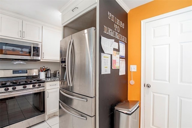 5302 Treaschwig Rd, Spring, TX 77373 - kitchen with stainless steel appliances, white cabinets, light tile patterned flooring, stone countertops, and ornamental molding