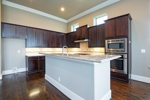 9948 Woodwind Ln N, Houston, TX 77025 - kitchen with stainless steel appliances, under cabinet range hood, light stone counters, dark brown cabinetry, and crown molding