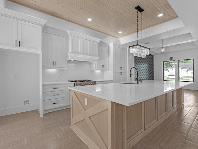 17107 Alara Dr, Splendora, TX 77372 - kitchen featuring a sink, light wood-style floors, wood ceiling, a large island with sink, and white cabinetry