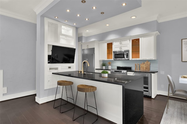 77 Chelsea Blvd, Houston, TX 77006 - kitchen with stainless steel appliances, ornamental molding, beverage cooler, dark countertops, and white cabinetry