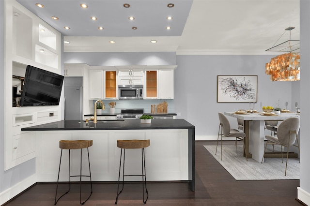77 Chelsea Blvd, Houston, TX 77006 - kitchen featuring a sink, white cabinets, stainless steel appliances, dark countertops, and crown molding