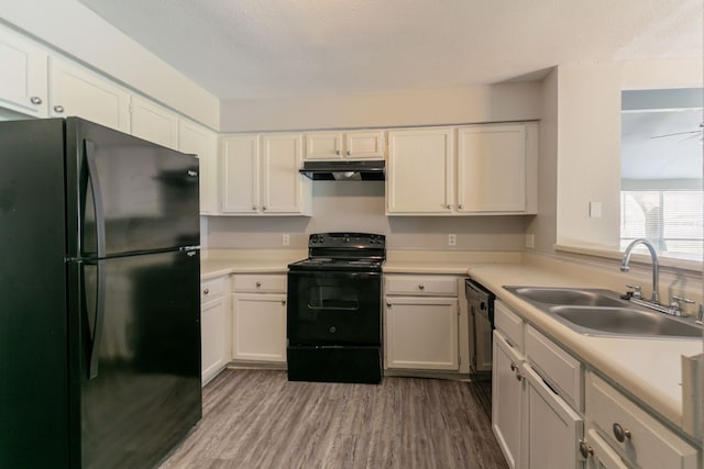 6930 Caddo Lake Ln, Houston, TX 77083 - kitchen featuring black appliances, under cabinet range hood, wood finished floors, and light countertops