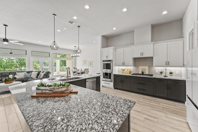 4215 Wooded Isle Way, Fulshear, TX 77441 - kitchen featuring a sink, appliances with stainless steel finishes, white cabinetry, a large island with sink, and recessed lighting