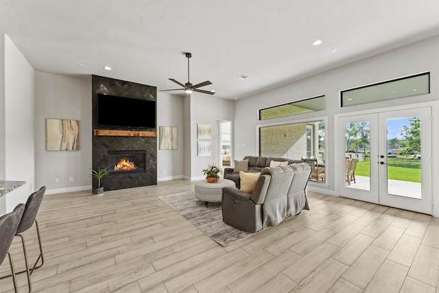 4215 Wooded Isle Way, Fulshear, TX 77441 - living area with ceiling fan, light wood-type flooring, a fireplace, recessed lighting, and a towering ceiling
