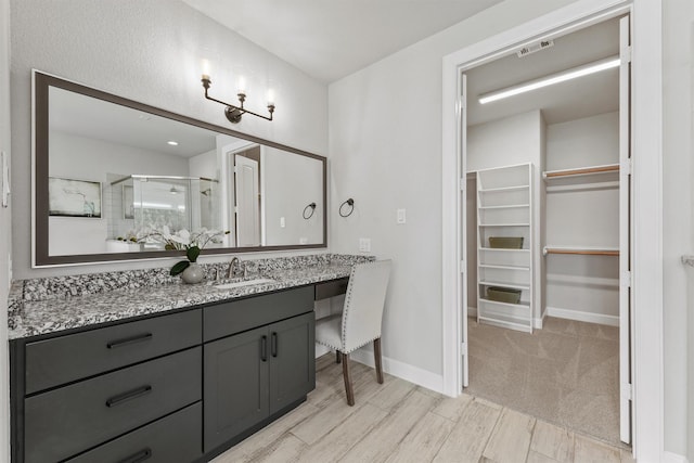 4215 Wooded Isle Way, Fulshear, TX 77441 - bathroom featuring a stall shower, vanity, a walk in closet, and baseboards