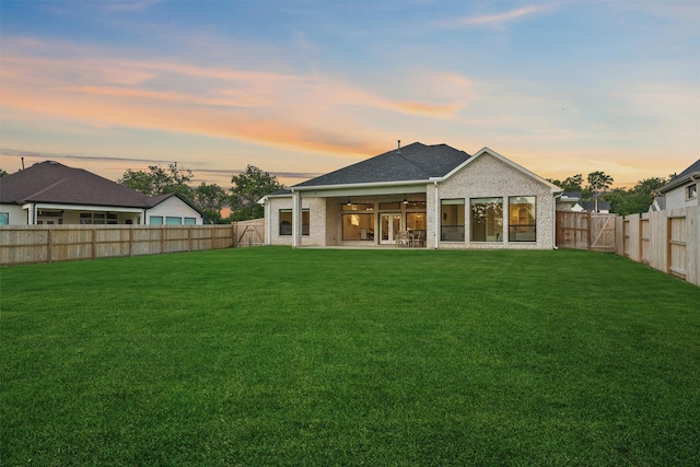 4215 Wooded Isle Way, Fulshear, TX 77441 - back of house at dusk with a ceiling fan, a patio, and brick siding
