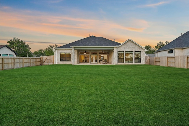 4215 Wooded Isle Way, Fulshear, TX 77441 - back of property at dusk with ceiling fan and french doors
