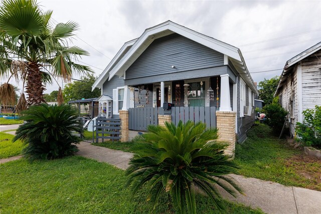 702 72nd St, Houston, TX 77011 - view of front facade featuring a porch and brick siding