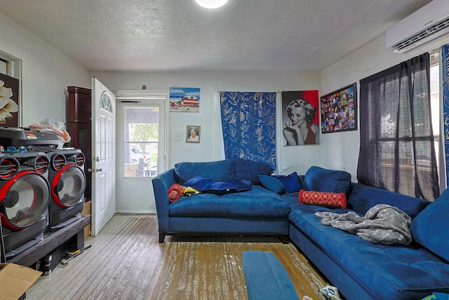 702 72nd St, Houston, TX 77011 - living room with separate washer and dryer, a wall mounted air conditioner, wood finished floors, and a textured ceiling