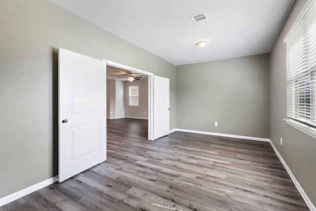 4438 Stephanie Park Ln, Conroe, TX 77304 - empty room with wood finished floors, plenty of natural light, and a ceiling fan