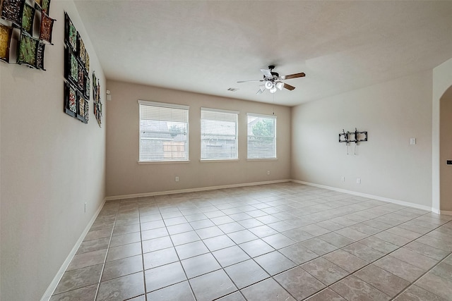 13322 Mesquite Stone Ln, Richmond, TX 77407 - empty room featuring a ceiling fan, light tile patterned floors, arched walkways, and baseboards