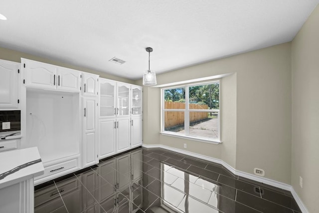 848 Nursery St, Clute, TX 77531 - kitchen with white cabinets, baseboards, decorative light fixtures, and tasteful backsplash