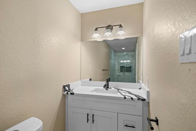 848 Nursery St, Clute, TX 77531 - full bathroom with a textured wall, a shower stall, vanity, and toilet