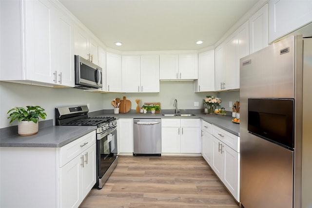 9510 Chesterfield Dr, Houston, TX 77051 - kitchen with stainless steel appliances, a sink, recessed lighting, white cabinetry, and light wood-style floors