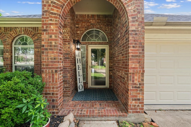 11411 Sugarbush Ridge Ln, Houston, TX 77089 - doorway to property featuring brick siding, a shingled roof, and an attached garage