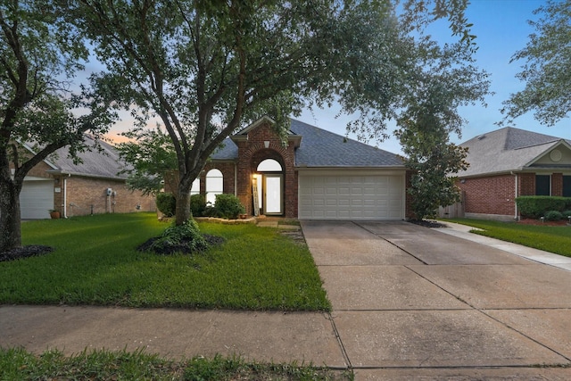 11411 Sugarbush Ridge Ln, Houston, TX 77089 - traditional-style house with brick siding, driveway, a front lawn, an attached garage, and a shingled roof