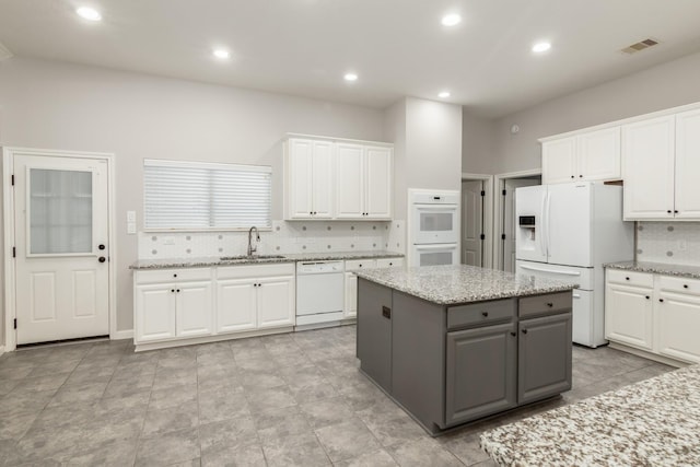 2119 Eagar Rd, League City, TX 77573 - kitchen with white appliances, a sink, gray cabinets, white cabinets, and tasteful backsplash