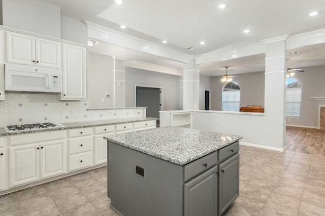 2119 Eagar Rd, League City, TX 77573 - kitchen featuring white appliances, decorative columns, gray cabinetry, ceiling fan, and a center island
