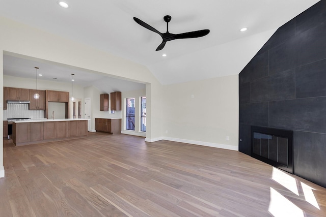 23135 Tranquil Springs Ln, Katy, TX 77494 - unfurnished living room with lofted ceiling, a ceiling fan, light wood-type flooring, a tile fireplace, and recessed lighting