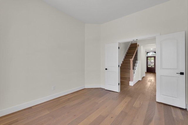 23135 Tranquil Springs Ln, Katy, TX 77494 - unfurnished room with baseboards, light wood-type flooring, and stairway