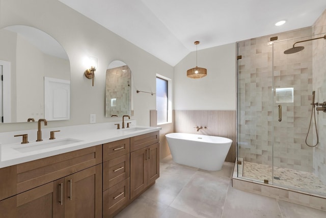 23135 Tranquil Springs Ln, Katy, TX 77494 - bathroom featuring a stall shower, a soaking tub, double vanity, lofted ceiling, and wainscoting