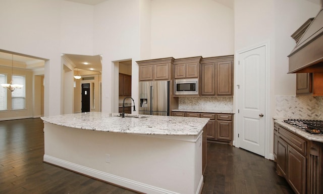 8823 Leaning Hollow Ln, Spring, TX 77379 - kitchen featuring appliances with stainless steel finishes, custom range hood, dark wood-style floors, a towering ceiling, and light stone counters