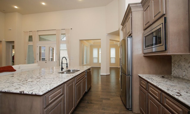 8823 Leaning Hollow Ln, Spring, TX 77379 - kitchen with stainless steel appliances, dark wood-style floors, a kitchen island with sink, light stone counters, and recessed lighting