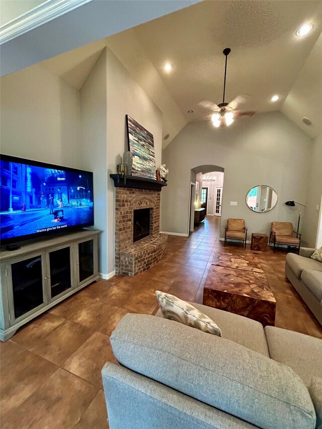 15127 Turquoise Mist Dr, Cypress, TX 77433 - tiled living area featuring arched walkways, ceiling fan, lofted ceiling, recessed lighting, and a fireplace