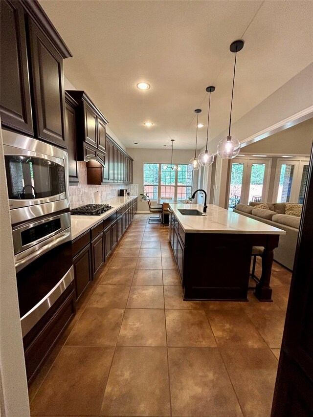 15127 Turquoise Mist Dr, Cypress, TX 77433 - kitchen with stainless steel appliances, a sink, backsplash, light countertops, and dark brown cabinetry