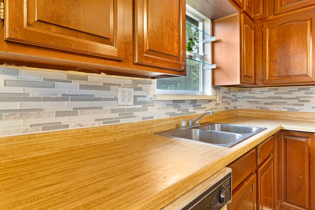 12 Walker Trl, Huntsville, TX 77320 - kitchen featuring a sink, light countertops, tasteful backsplash, and brown cabinets