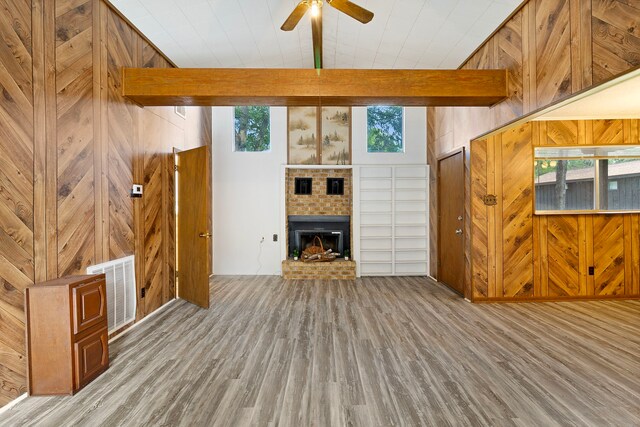 12 Walker Trl, Huntsville, TX 77320 - unfurnished living room with wood finished floors, a fireplace, healthy amount of natural light, and wood walls